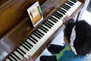 First grade students playing piano with Mr Music Music School on tablet